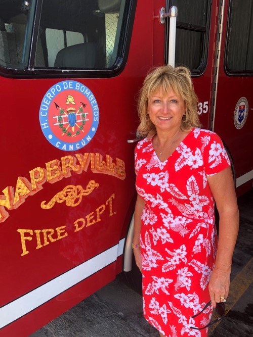 Councilwoman Patty Gustin stands by Naperville Fire truck in Cancun