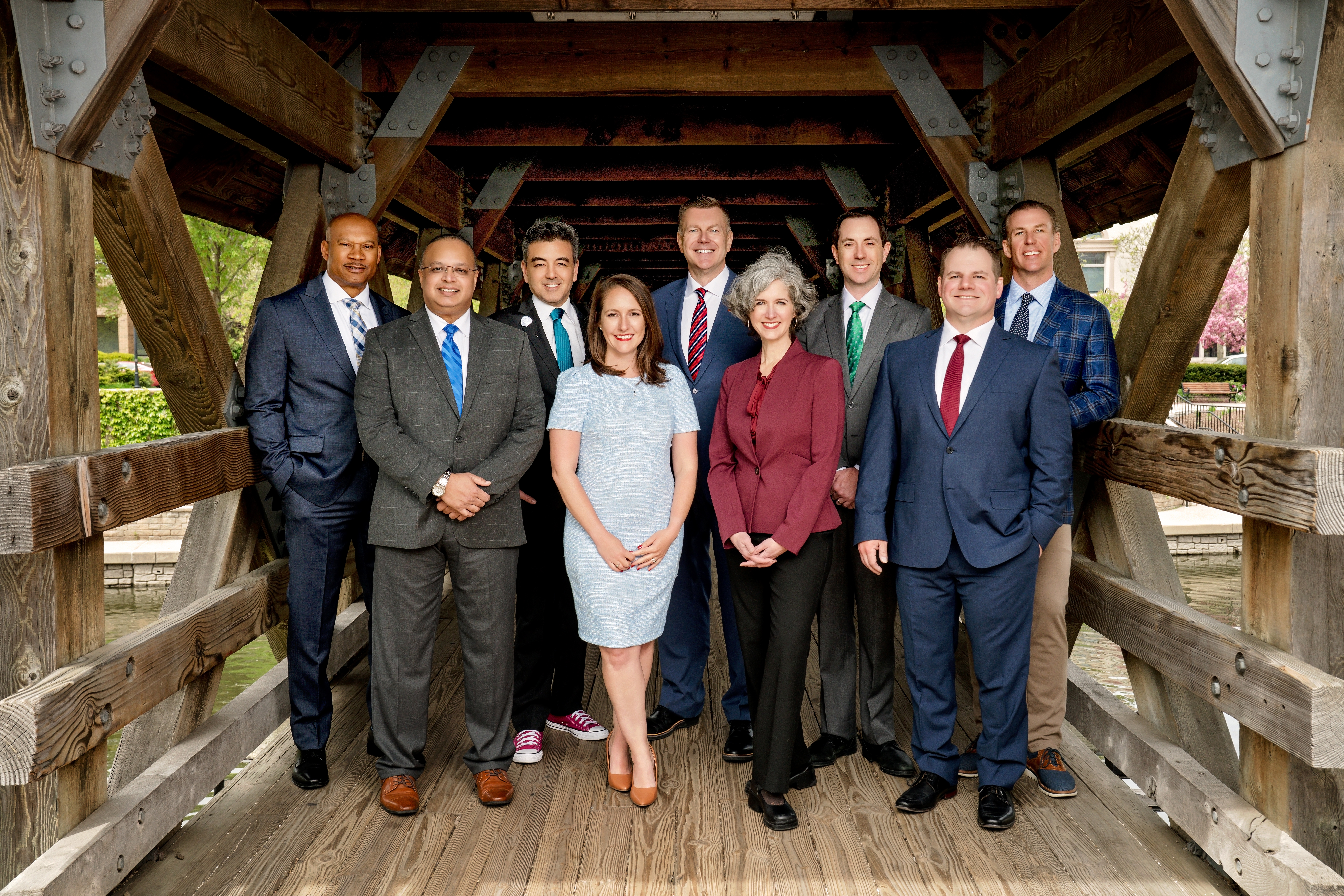 Members of the Naperville City Council stand on a covered bridge in the city.