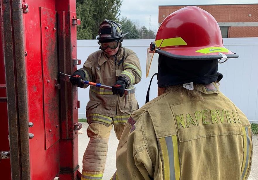 Naperville Explorers in full gear attempt to pry open a door during training