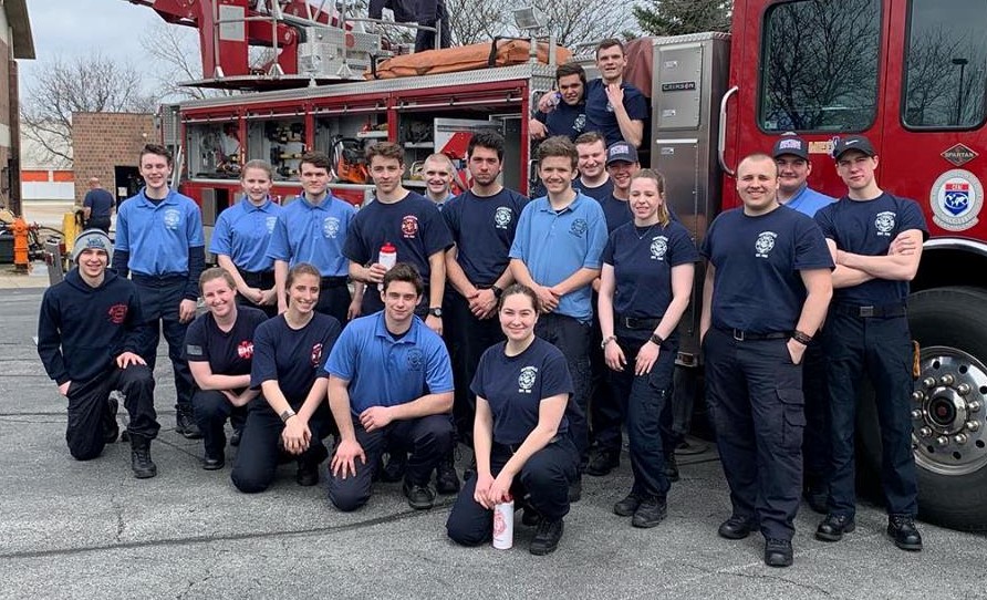 Many Naperville Fire Explorers pose in front of a Naperville fire truck