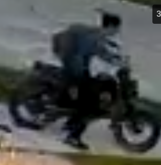 surveillance photo of young man on e-motor wearing black hat and backpack