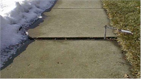 a section of sidewalk in which one slab is sunken below another