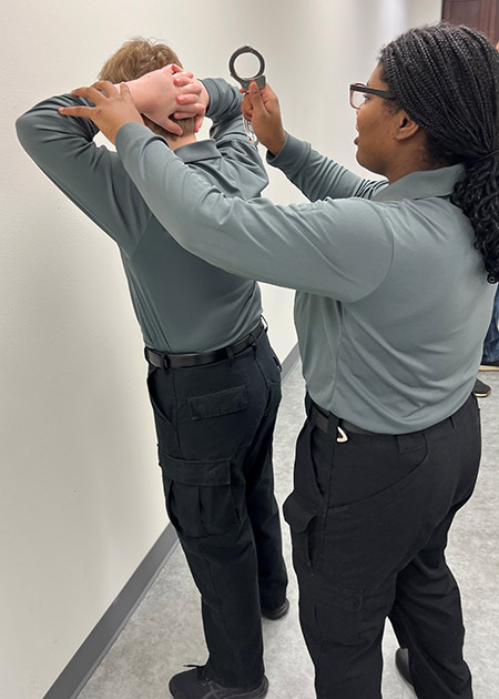 a cadet practices handcuffing techniques on another cadet