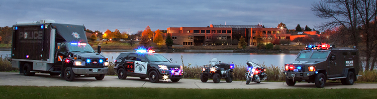 police vehicles with lights on lined up in front of station