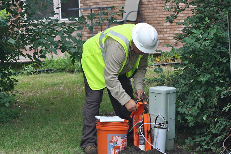 A Novinium representative installs an injection elbow and vacuum tank on a transformer to begin the electrical cable injection process.